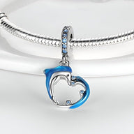 Charm pendentif dauphin et vague en acier avec détails bleus et strass sur anneau, style élégant.