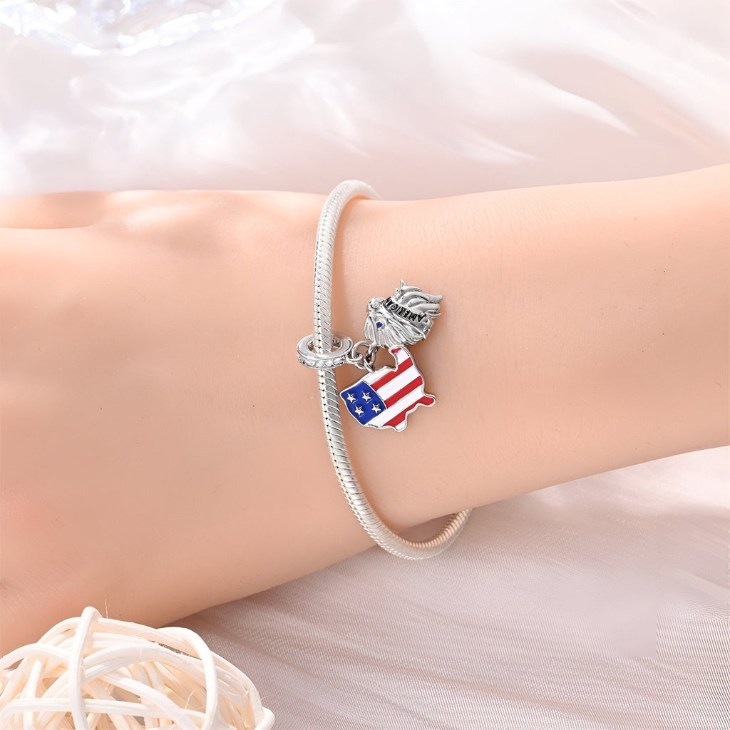 Bracelet argenté avec pendentif drapeau américain et aigle détaillé en métal sur poignet féminin.