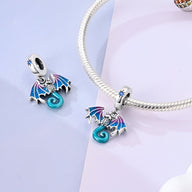 Charm pendentif dragon bleu en émail avec ailes violettes sur chaîne serpent argentée.