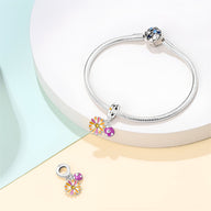 Bracelet argent avec pendentif chrysanthème coloré et petite coccinelle rose.