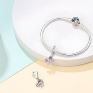 Bracelet argenté avec pendentif coeur et libellule colorée, design élégant et fin.