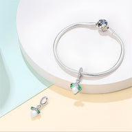 Bracelet en argent avec pendentif luciole translucide blanc et ailes vertes, design délicat.