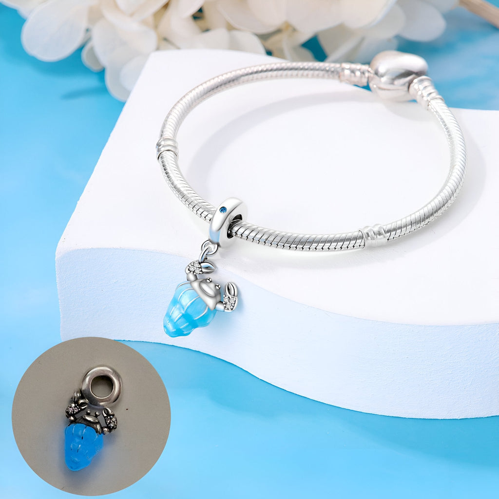 Bracelet argent avec pendentif charm bleu en forme de pagure détail papillon.