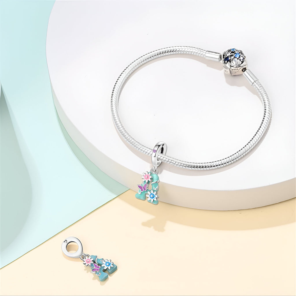 Bracelet en argent avec pendentif fleur multicolore et breloque amovible en forme de fleur.