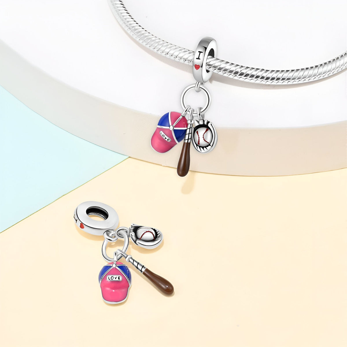 Pendentif charme baseball femme avec batte, casquette rose et balle argentée sur chaîne serpent argenté.