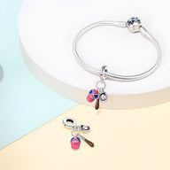 Bracelet argenté avec pendentifs baseball colorés, batte, gant et balle stylisée.