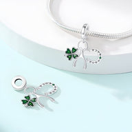 Ensemble de charms porte-bonheur argentés avec trèfle vert et fer à cheval orné de strass sur chaîne serpent argentée.