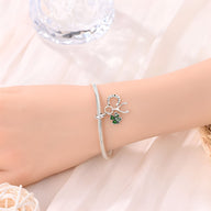 Bracelet argent fin avec pendentif trèfle vert et détail cercle texturé élégant.