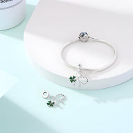 Bracelet argenté avec pendentifs porte-bonheur trèfle vert et chiffre 8 scintillant.