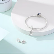 Bracelet argent avec pendentif fer à cheval et trèfle serti de pierres bleues et blanches.