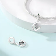 Pendentif fer à cheval argenté avec trèfle à quatre feuilles et strass blancs, style porte-bonheur.