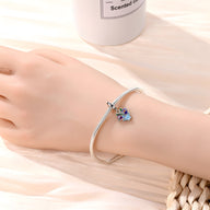 Bracelet argenté fin avec pendentif fleur de pensée colorée bleu et violet.