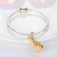 Bracelet argenté avec pendentif girafe jaune et noir détail réaliste.