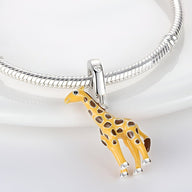 Charm pendentif girafe jaune en émail avec détails argentés sur bracelet serpent argenté.
