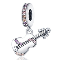 Charm pendentif guitare argenté orné de cristaux roses et violets.