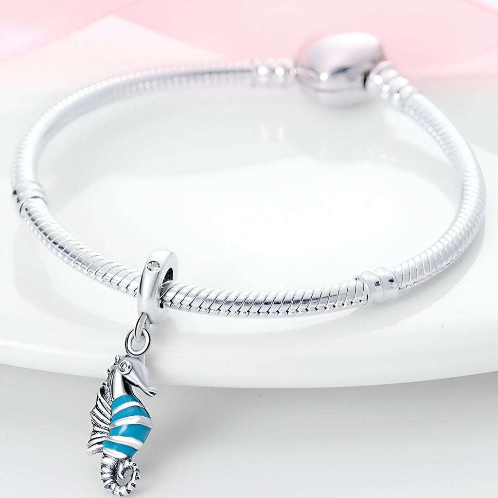 Bracelet argent avec pendentif hippocampe bleu et blanc rayé en émail.