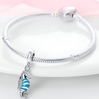 Bracelet argent avec pendentif hippocampe bleu et blanc rayé en émail.