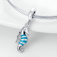 Pendentif hippocampe argenté avec détails en émail bleu et blanc, pour bracelet.