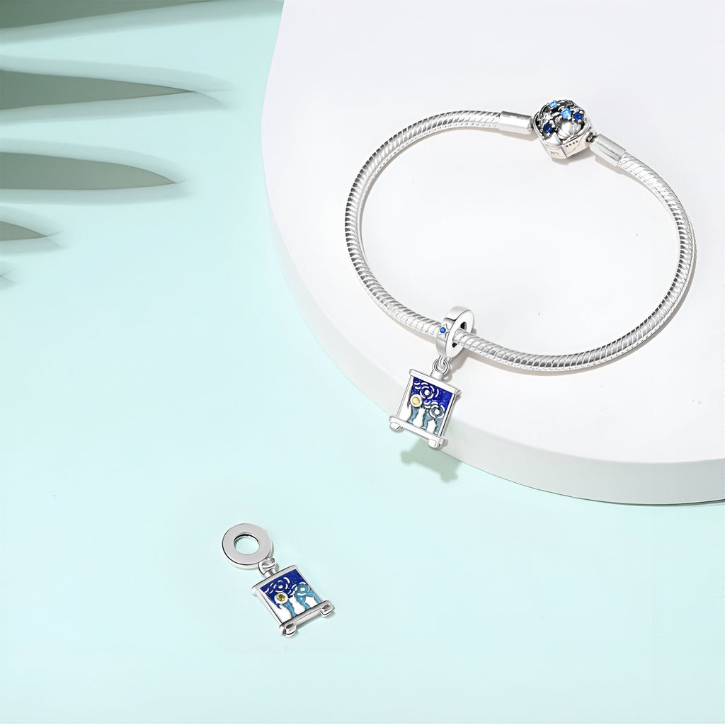 Bracelet argent avec pendentif charm carré bleu et motifs étoiles inspirés de La Nuit Étoilée de Van Gogh, plus un charm.