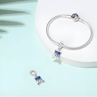 Bracelet argent avec pendentif charm carré bleu et motifs étoiles inspirés de La Nuit Étoilée de Van Gogh, plus un charm.