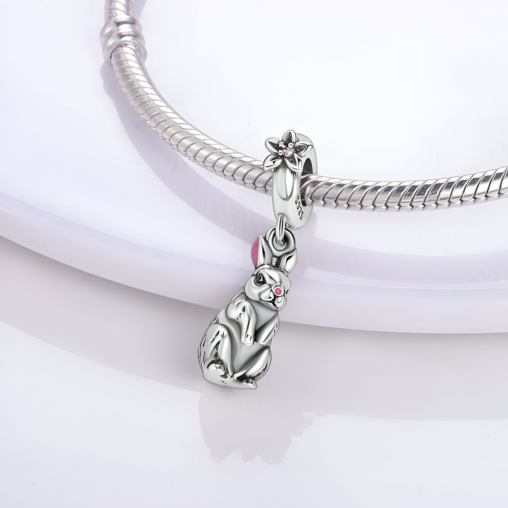 Charm pendentif lapin assis en argent avec détail perle rose, style élégant et fin.