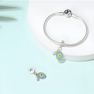 Bracelet argenté avec pendentif charm tournesols colorés bleu et jaune sur fond blanc.