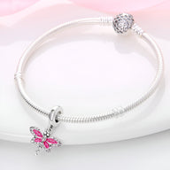 Bracelet argenté avec pendentif libellule rose en émail et détails délicats.