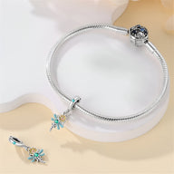 Bracelet argenté avec pendentif libellule turquoise sur marguerite blanche et breloque assortie.