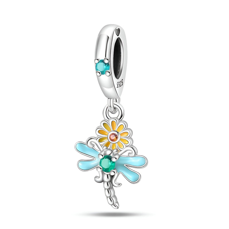Pendentif charm libellule argent avec ailes bleu clair, fleur marguerite blanche et jaune, détail turquoise.