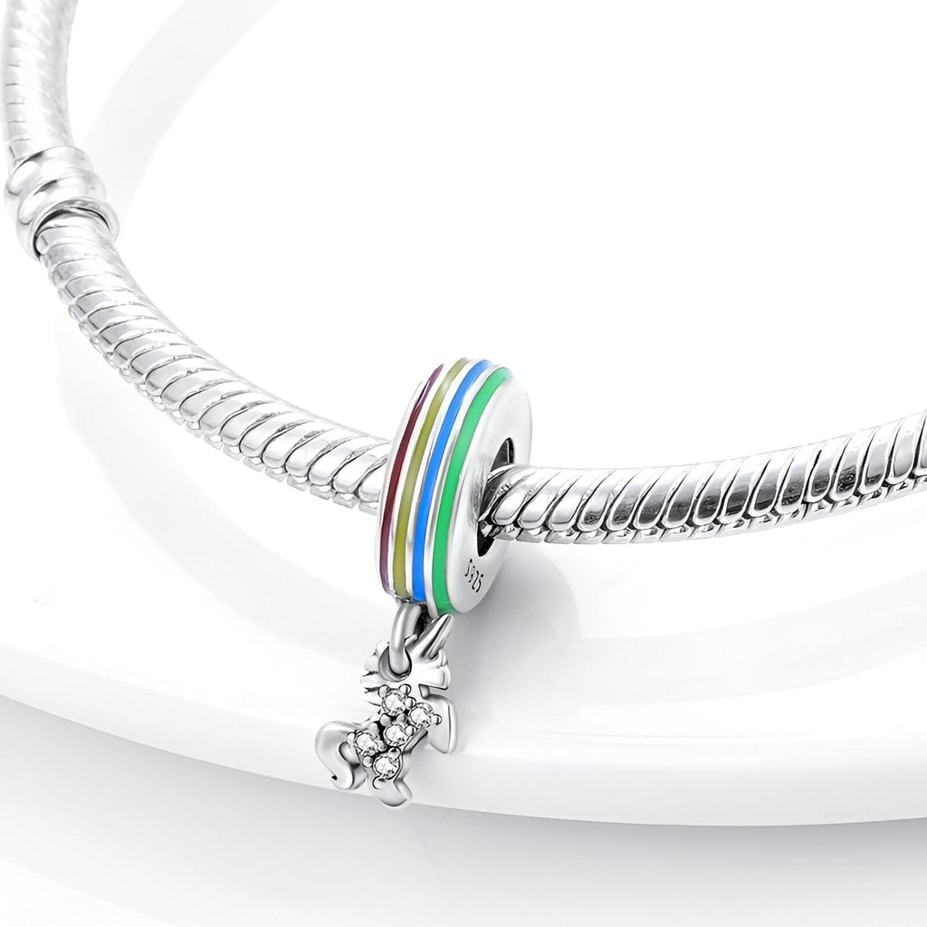 Charm pendant licorne en argent avec anneau multicolore arc-en-ciel sur bracelet serpent argenté.