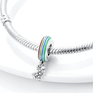 Charm pendant licorne en argent avec anneau multicolore arc-en-ciel sur bracelet serpent argenté.