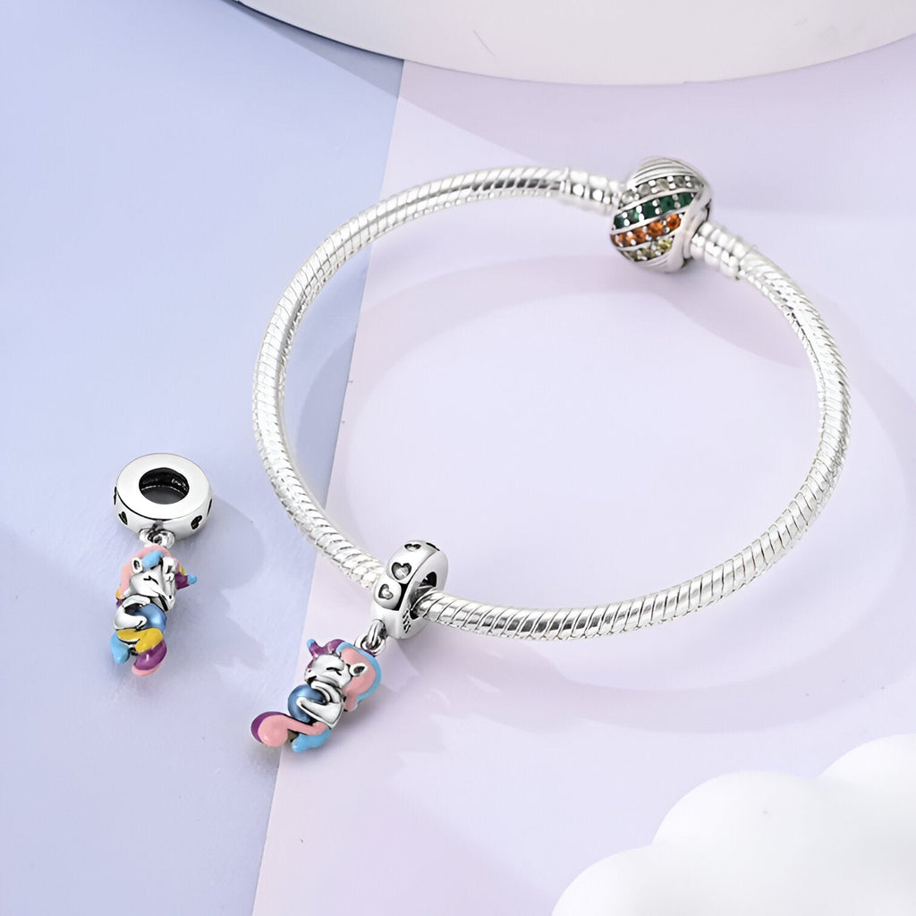 Bracelet argent avec charm pendentif licorne colorée et breloque cœur en argent.