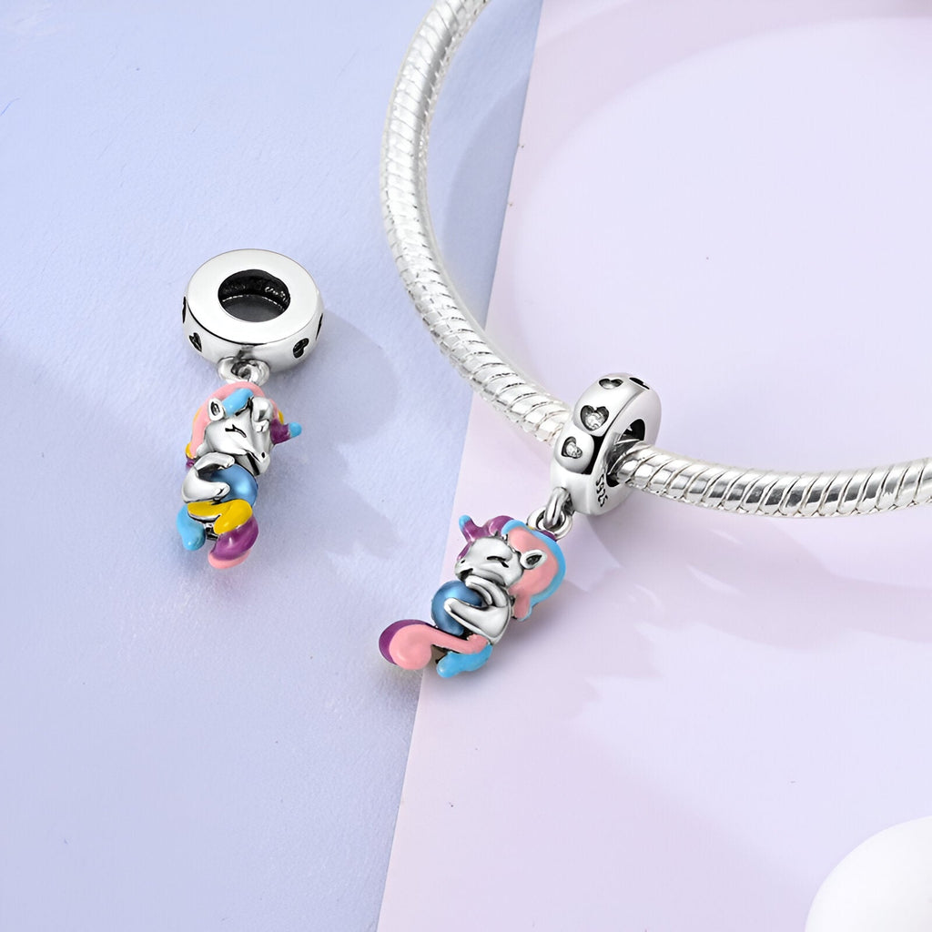 Pendentif licorne coloré avec détails bleu, rose et jaune, monté sur bracelet argenté lisse.