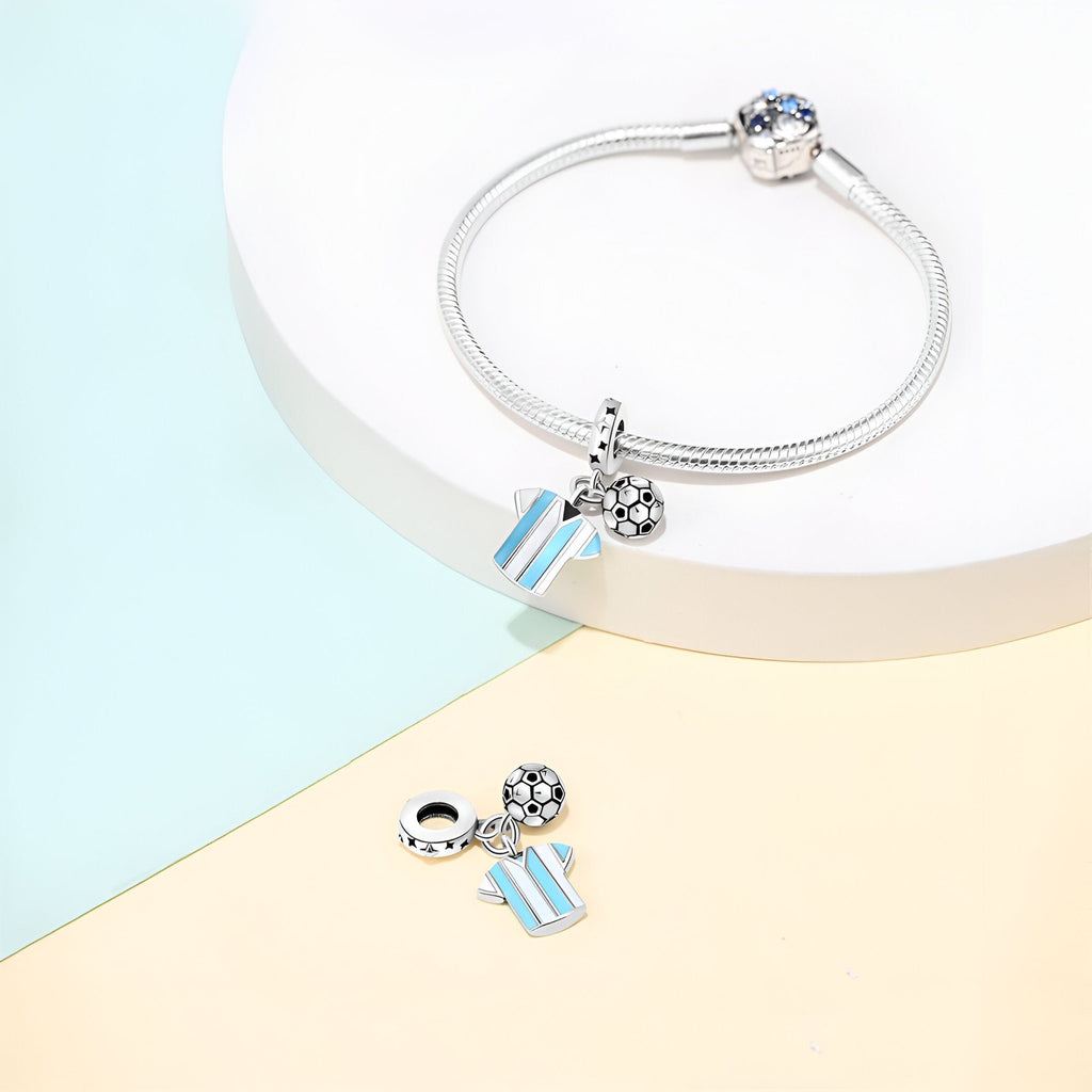 Bracelet argenté avec pendentifs maillot bleu clair et blanc et ballon de foot détail noir et blanc.