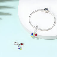 Bracelet argent avec pendentif main colorée remplie de peinture et petit tube de peinture en métal rouge.