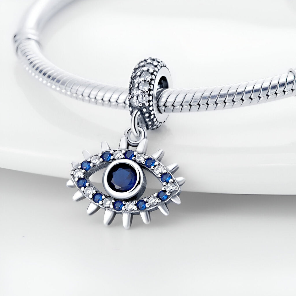 Pendentif œil de protection en argent avec pierres bleues serties, bracelet serpent argenté.