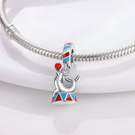 Charm pendentif otarie argentée sur un tambour rouge et bleu, sur bracelet serpent argenté.