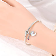 Bracelet argenté avec pendentif palette de peinture colorée et pinceau finement détaillé.