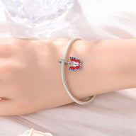 Bracelet argenté avec pendentif papillon rouge et bleu, style élégant et fin.