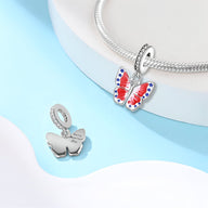 Charm pendentif papillon en argent avec ailes rouges, blanches et bleues, finitions lisses.