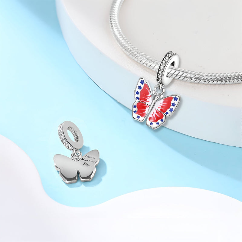 Charm pendentif papillon en argent avec ailes rouges, blanches et bleues, finitions lisses.