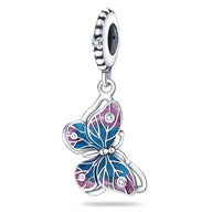 Charm pendentif papillon en argent avec ailes bleues et roses ornées de petits cristaux blancs.
