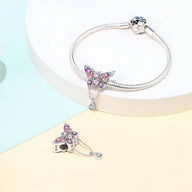 Bracelet argenté avec pendentif papillon orné de pierres roses et blanches brillantes.