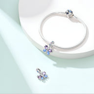 Charm argenté papillon aux ailes bleues et violettes avec bracelet serpent en argent.