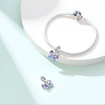 Charm argenté papillon aux ailes bleues et violettes avec bracelet serpent en argent.