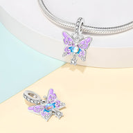 Charm pendentif papillon en métal argenté avec émail violet et strass bleu brillant.