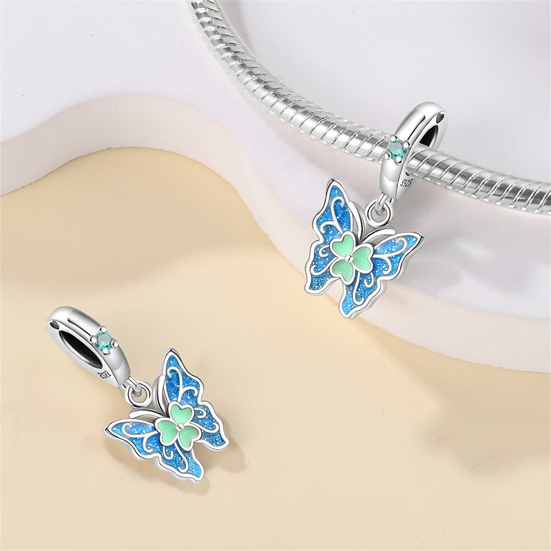 Pendentif papillon en argent avec émail bleu et vert, détail cœur vert pâle, anneau strass turquoise.