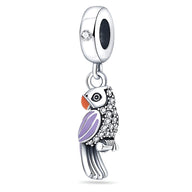 Pendentif charme perroquet en argent avec ailes violettes et détails orange et noirs, orné de pierres blanches brillantes.