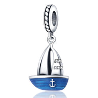 Charm pendentif petit bateau en argent avec coque bleue et ancre blanche, voiles stylisées.