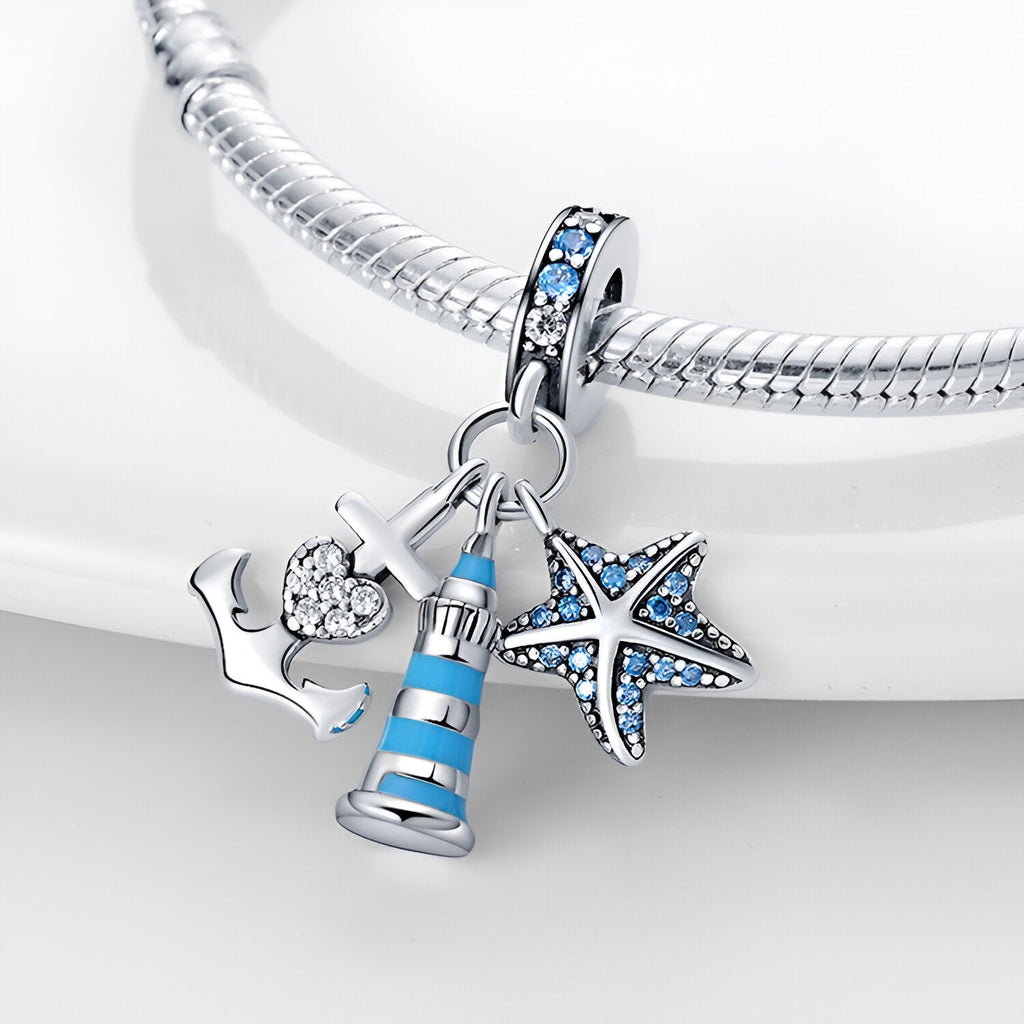 Charm pendentif en argent avec phare bleu et blanc, étoile de mer bleue et ancre élégante sur bracelet serpent.
